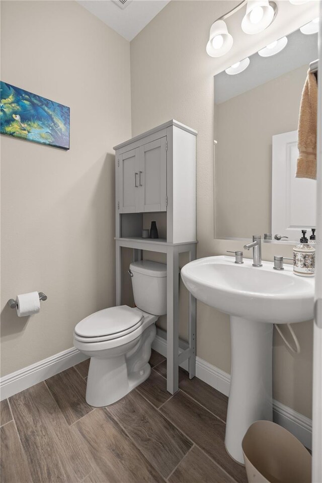 bathroom with sink, hardwood / wood-style flooring, and toilet