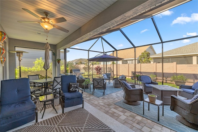 view of patio featuring glass enclosure, ceiling fan, and outdoor lounge area