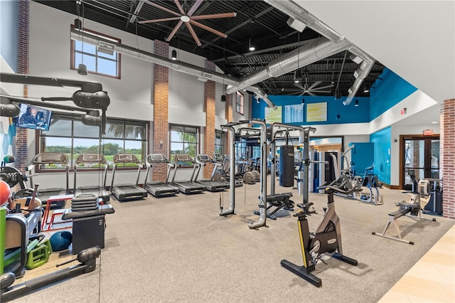 workout area with ceiling fan and a high ceiling