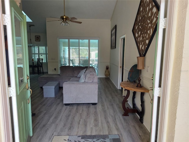 living room featuring light wood-type flooring, crown molding, and ceiling fan