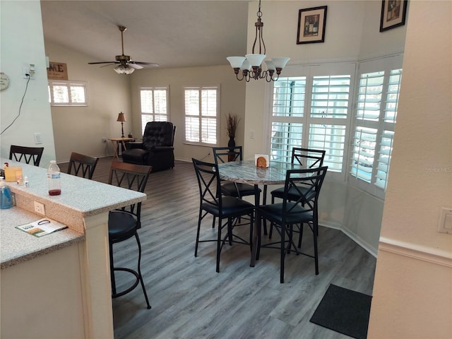 dining space with ceiling fan with notable chandelier and hardwood / wood-style floors