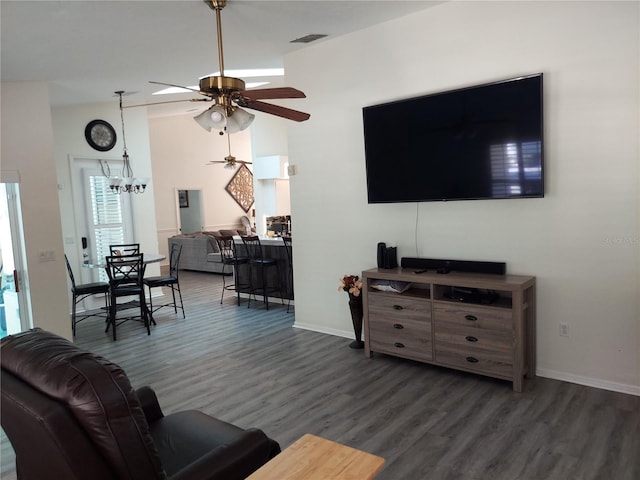 living room with ceiling fan with notable chandelier and dark wood-type flooring