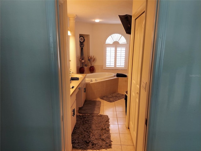 bathroom with tile patterned flooring, tiled bath, and vanity