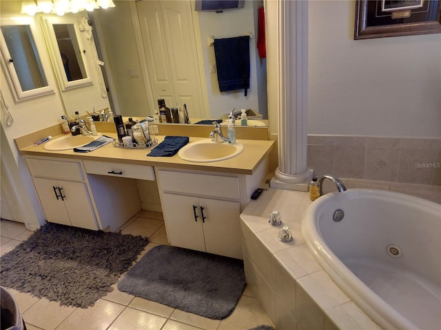 bathroom featuring vanity, tiled tub, decorative columns, and tile patterned floors