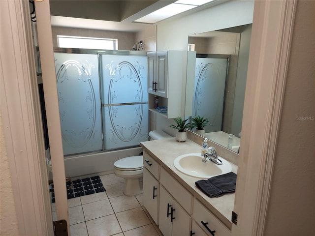 full bathroom featuring bath / shower combo with glass door, vanity, toilet, and tile patterned floors