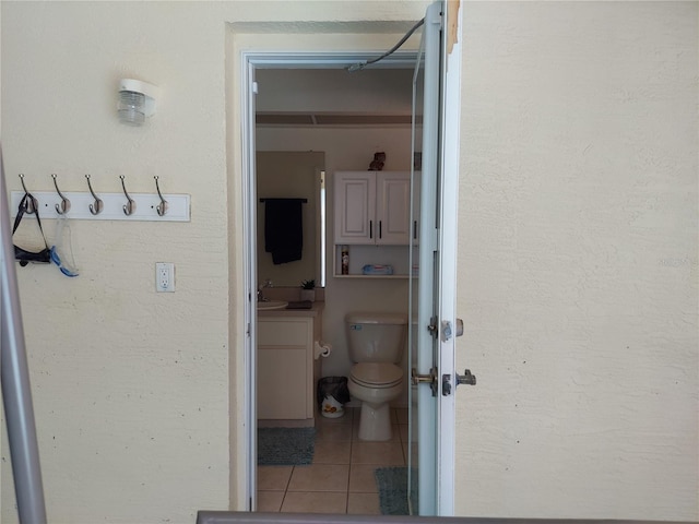 bathroom with sink, toilet, and tile patterned floors