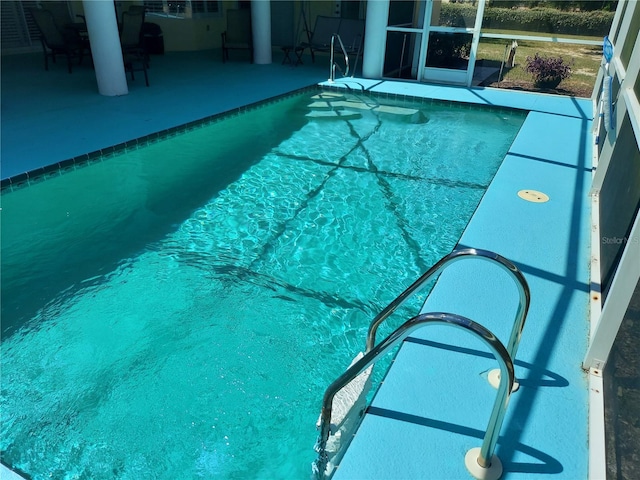 view of pool with a patio and glass enclosure