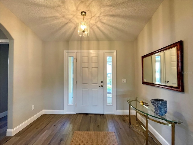 foyer entrance with wood-type flooring and a textured ceiling