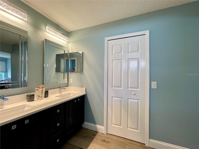 bathroom featuring vanity, hardwood / wood-style flooring, and a textured ceiling