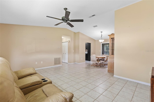 living room with lofted ceiling, visible vents, and light tile patterned flooring