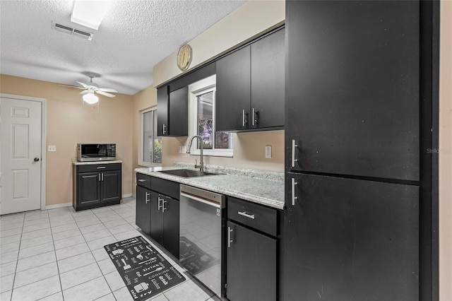 kitchen featuring appliances with stainless steel finishes, light countertops, dark cabinetry, a sink, and light tile patterned flooring