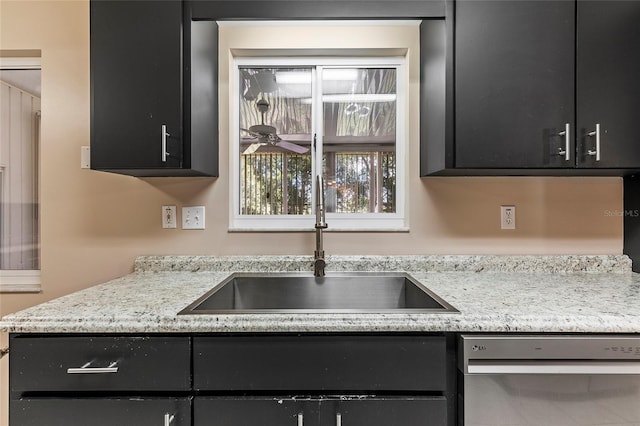 kitchen featuring a sink, dark cabinets, and stainless steel dishwasher