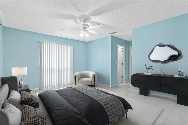 bedroom featuring light tile patterned floors, ceiling fan, a textured ceiling, visible vents, and baseboards