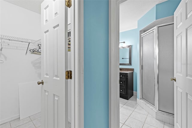 hall featuring light tile patterned floors and a textured ceiling