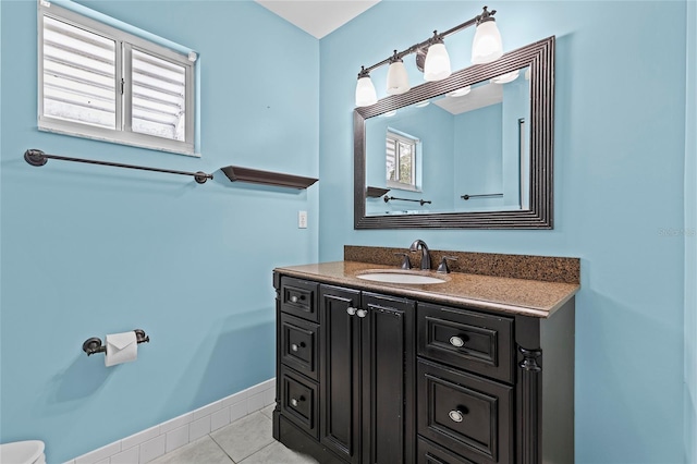 bathroom with tile patterned flooring, baseboards, and vanity