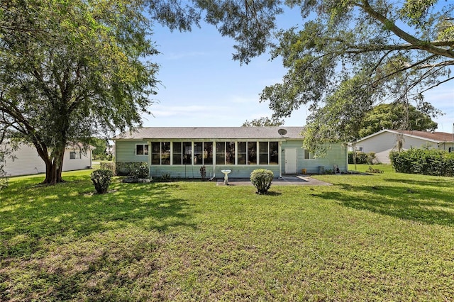 back of house with a sunroom and a yard