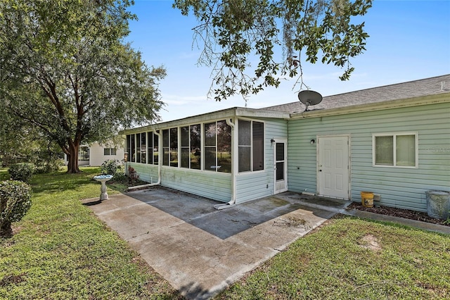 exterior space featuring a sunroom, a yard, and a patio