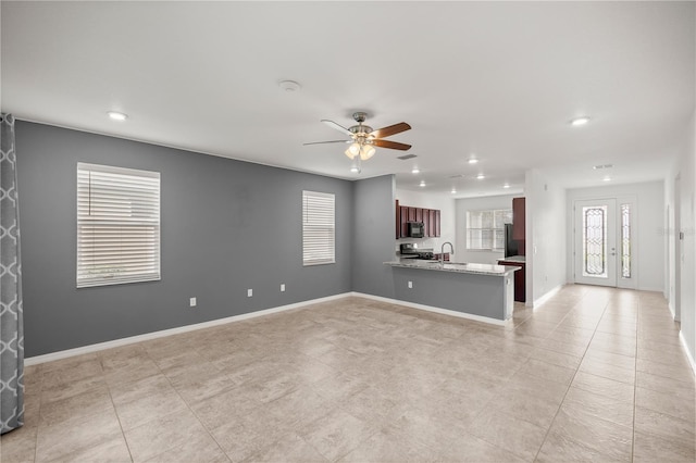 unfurnished living room with ceiling fan and sink