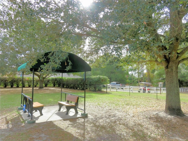 view of property's community with a patio and a lawn