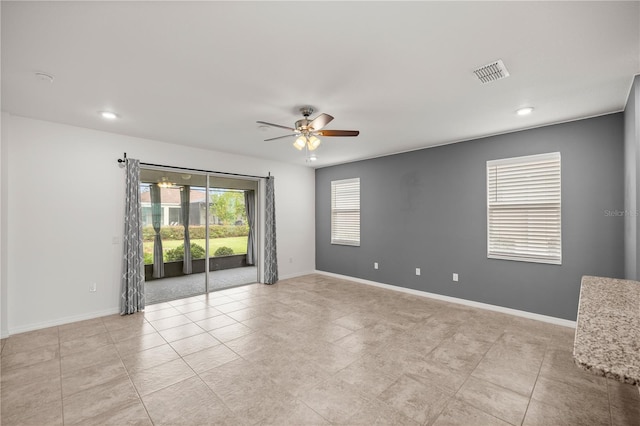 tiled spare room featuring ceiling fan