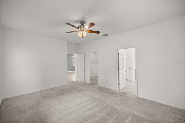 empty room featuring ceiling fan and light colored carpet