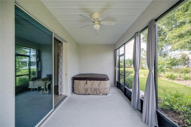 unfurnished sunroom with ceiling fan