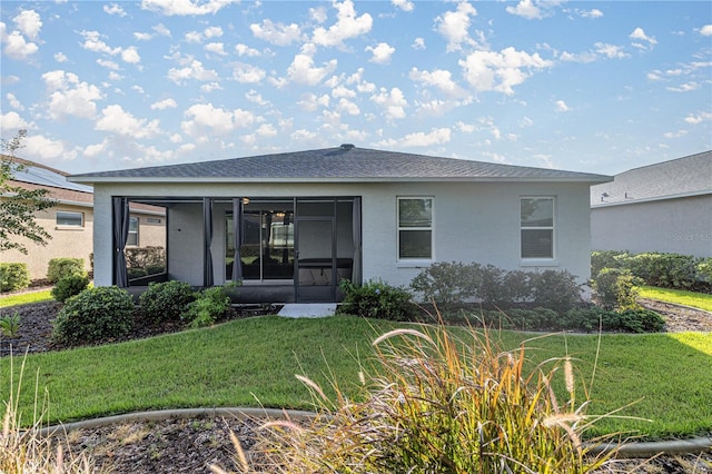 rear view of property featuring a sunroom and a yard