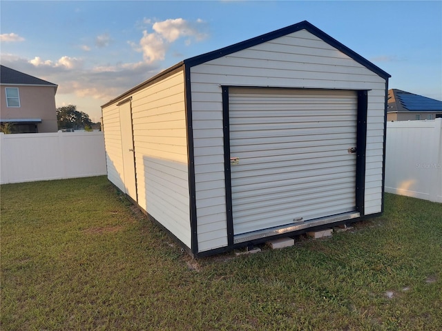 outdoor structure at dusk with a garage and a yard