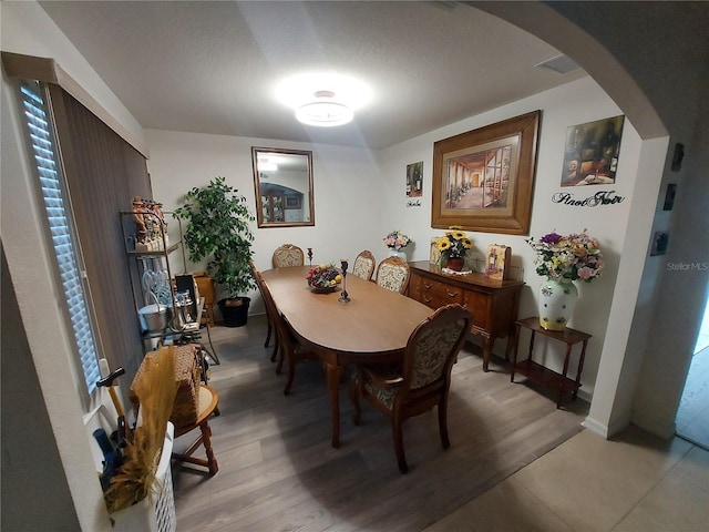 dining area with a textured ceiling and hardwood / wood-style floors