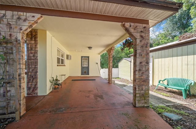 view of patio / terrace with fence and an outbuilding