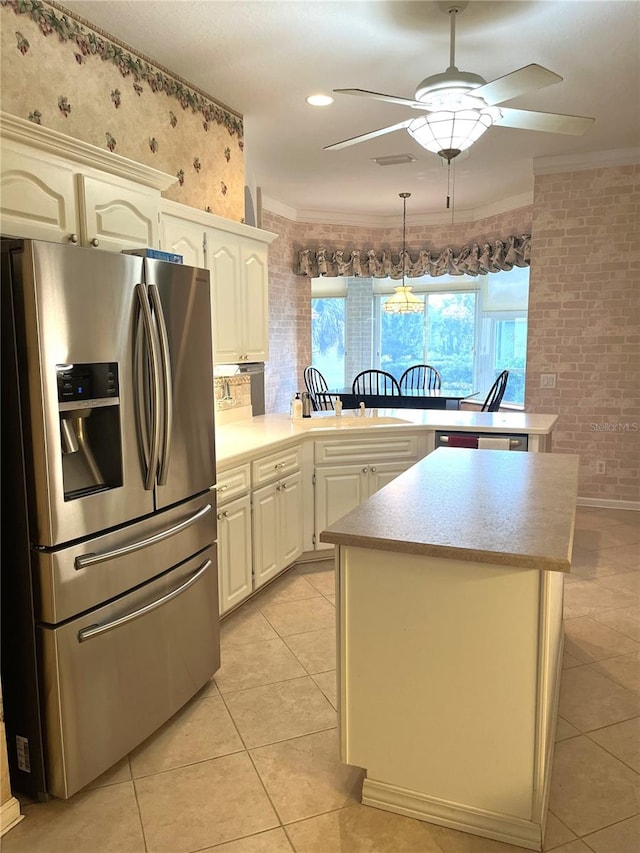 kitchen featuring light tile patterned flooring, stainless steel fridge with ice dispenser, kitchen peninsula, crown molding, and ceiling fan