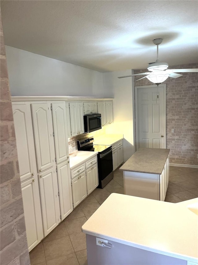 kitchen featuring electric stove, a center island, white cabinetry, and ceiling fan