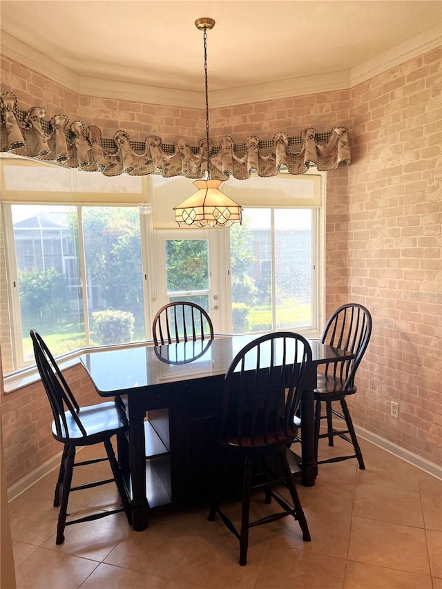 tiled dining space featuring brick wall and crown molding