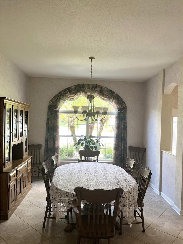 tiled dining space with an inviting chandelier and a textured ceiling