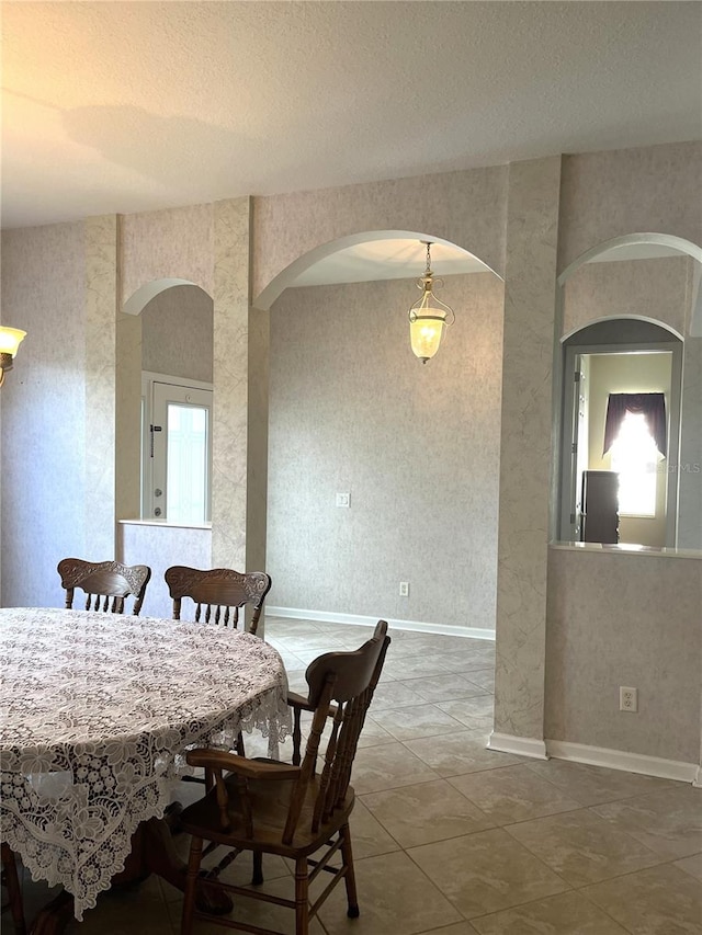 dining room featuring a textured ceiling and tile patterned flooring