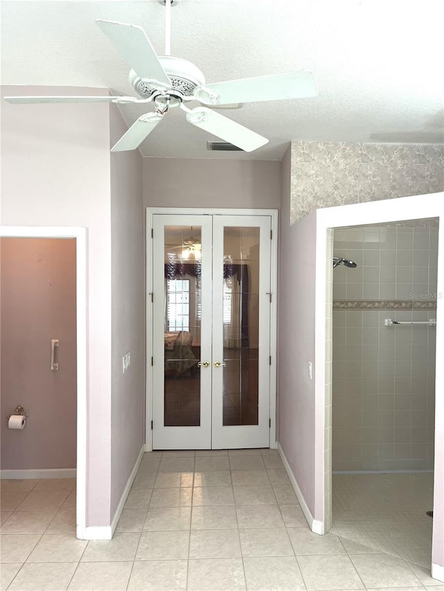 unfurnished bedroom featuring light tile patterned floors, ceiling fan, and french doors