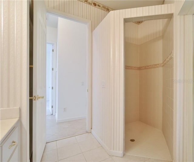 bathroom with vanity, tile patterned flooring, and tiled shower