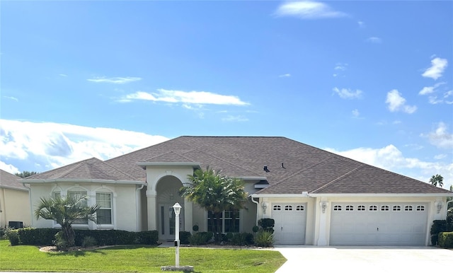 view of front of home featuring a front yard, a garage, and central AC unit