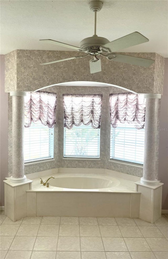 bathroom featuring a bath, a healthy amount of sunlight, and ceiling fan