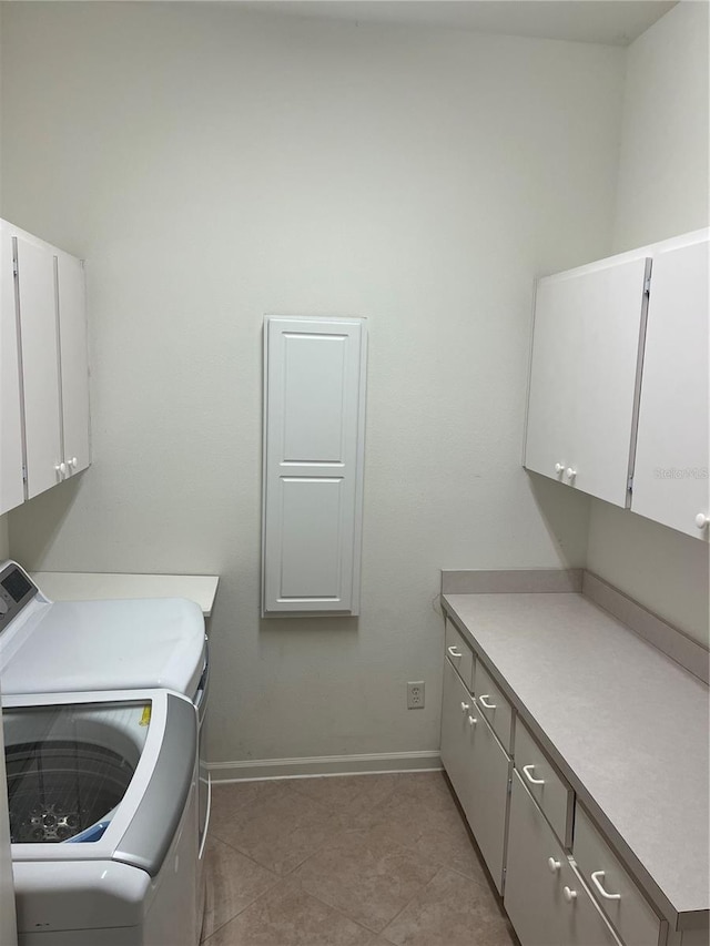 laundry area featuring cabinets, washing machine and clothes dryer, and light tile patterned flooring