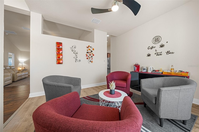 living room featuring light wood-type flooring, vaulted ceiling, and ceiling fan