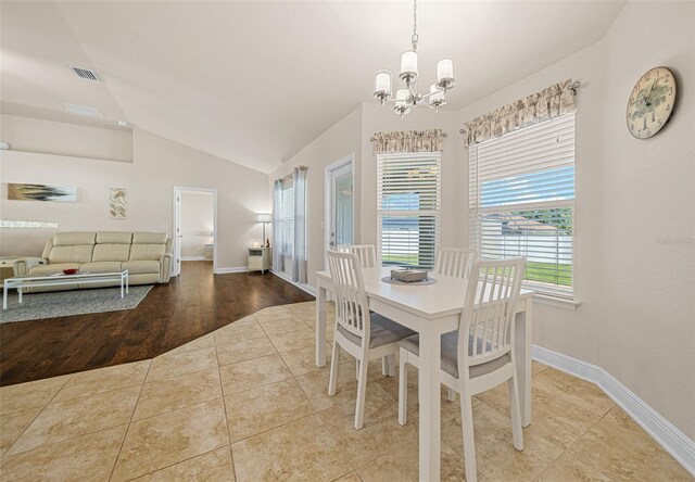 dining space featuring vaulted ceiling, a notable chandelier, and light hardwood / wood-style floors