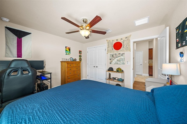 bedroom with ceiling fan, a closet, and wood-type flooring