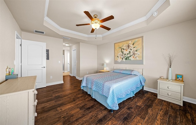 bedroom with a tray ceiling, ceiling fan, dark wood-type flooring, and crown molding