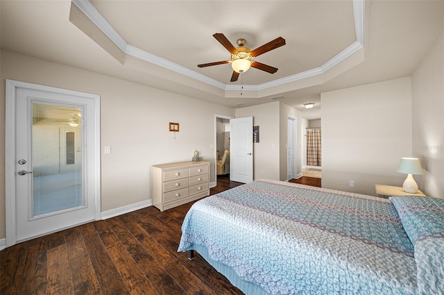 bedroom with ceiling fan, a tray ceiling, dark hardwood / wood-style floors, and ornamental molding