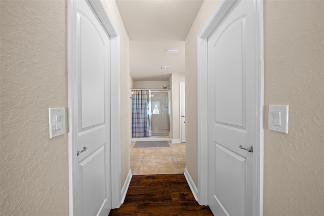 hall with a textured ceiling and hardwood / wood-style flooring