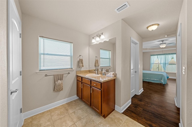 bathroom featuring ceiling fan, vanity, hardwood / wood-style floors, and a textured ceiling