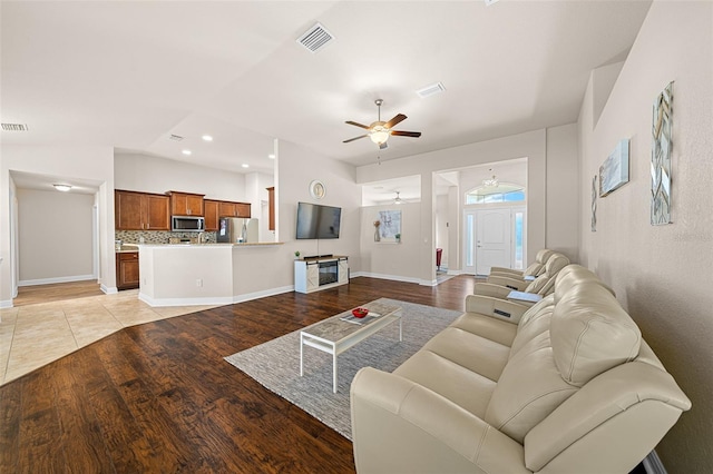 living room featuring light hardwood / wood-style flooring, lofted ceiling, and ceiling fan