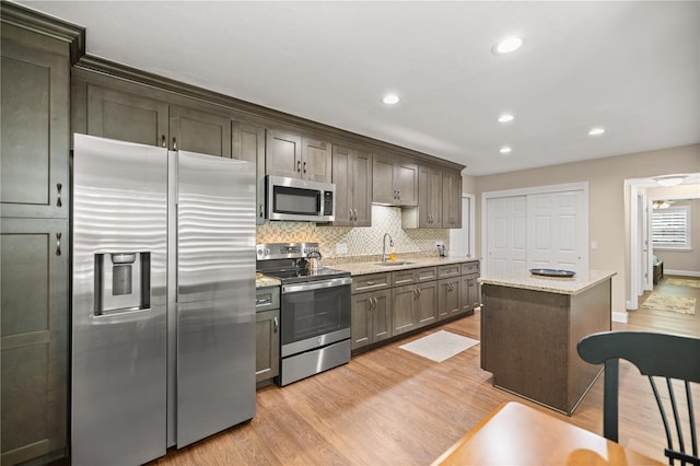 kitchen featuring light wood-type flooring, a center island, sink, and stainless steel appliances