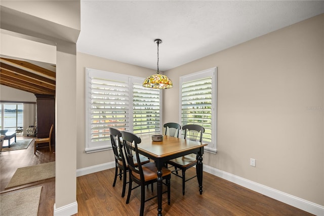 dining area featuring lofted ceiling with beams, dark hardwood / wood-style floors, and plenty of natural light